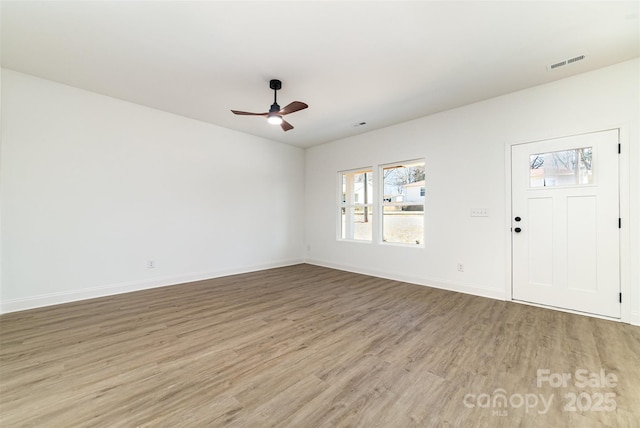 interior space with baseboards, visible vents, ceiling fan, and wood finished floors