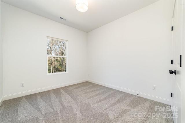 carpeted empty room featuring visible vents and baseboards