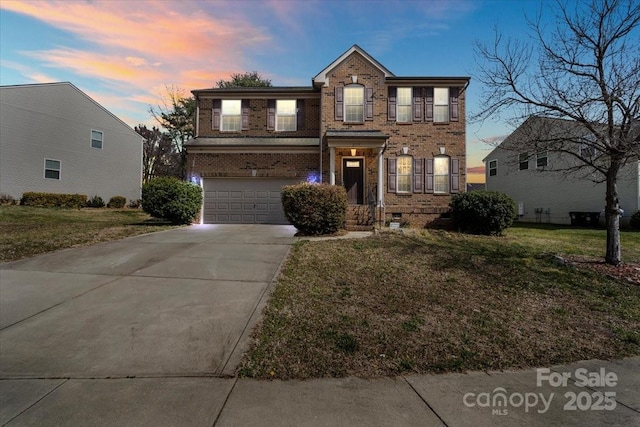 view of front of house with a garage, driveway, brick siding, and a front yard