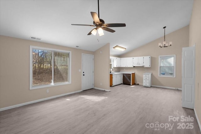 unfurnished living room featuring baseboards, visible vents, lofted ceiling, light wood-style floors, and ceiling fan with notable chandelier