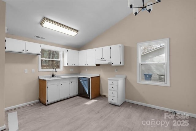 kitchen featuring lofted ceiling, under cabinet range hood, a sink, visible vents, and dishwasher