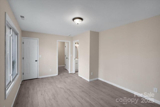 unfurnished bedroom with visible vents, baseboards, and wood finished floors