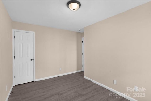 unfurnished room featuring baseboards and wood finished floors