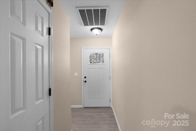 entryway with baseboards, visible vents, and wood finished floors