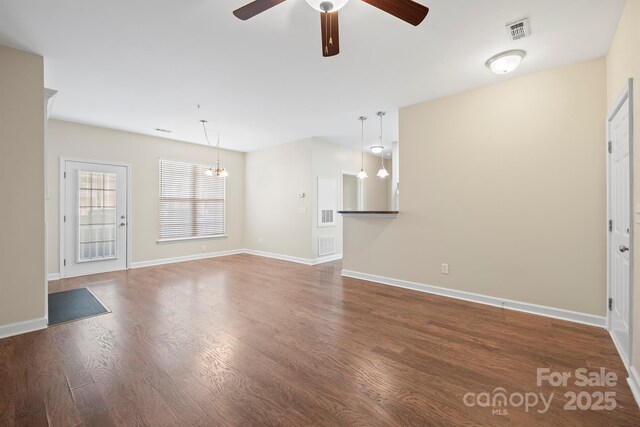 unfurnished living room featuring ceiling fan, wood finished floors, visible vents, and baseboards