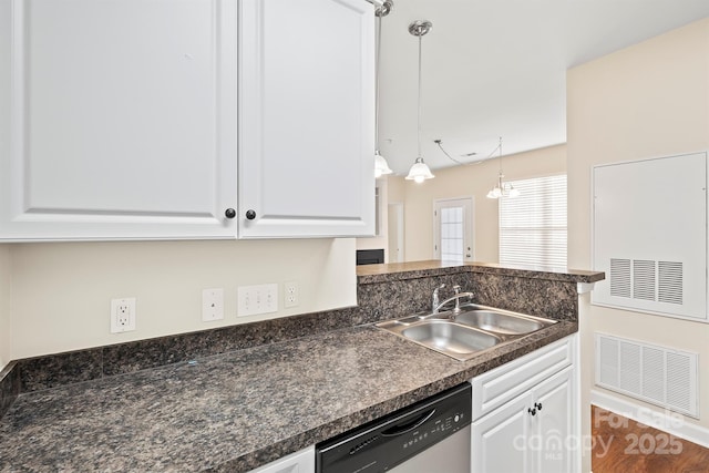 kitchen with dishwasher, dark countertops, a sink, and white cabinetry