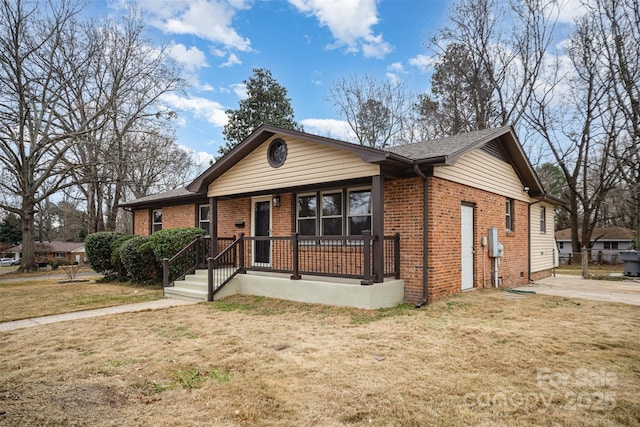 ranch-style home with covered porch, brick siding, and a front lawn