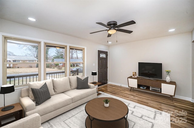 living room featuring ceiling fan, baseboards, wood finished floors, and recessed lighting