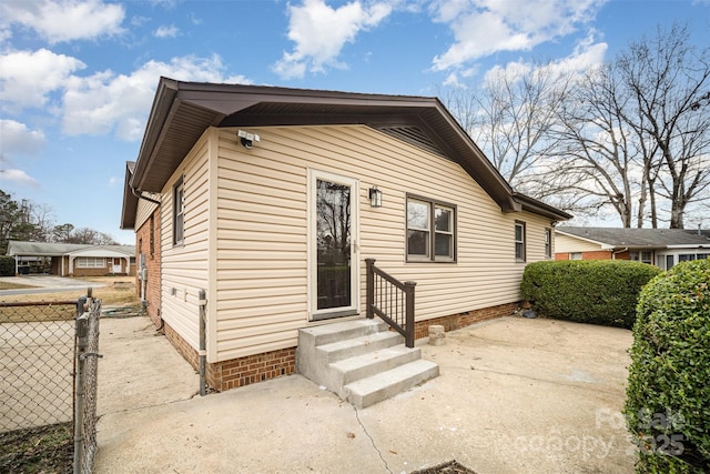 view of front of property featuring entry steps, a patio area, and fence