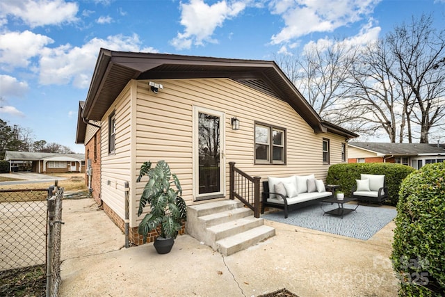 back of property featuring a patio area, outdoor lounge area, fence, and entry steps