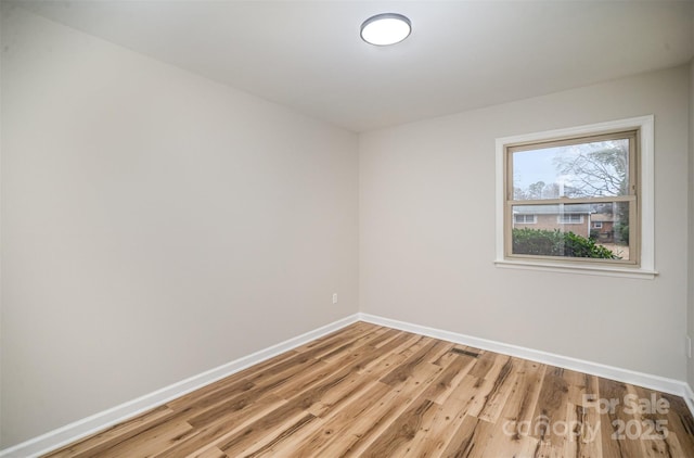 unfurnished room featuring light wood-type flooring and baseboards