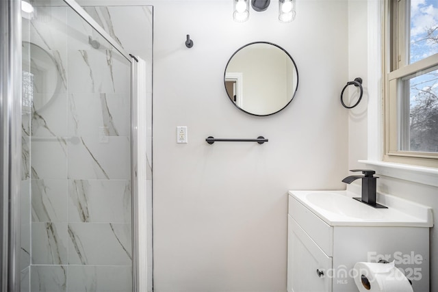 bathroom featuring vanity and a marble finish shower