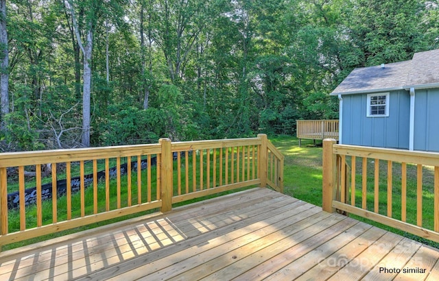 wooden deck featuring a lawn