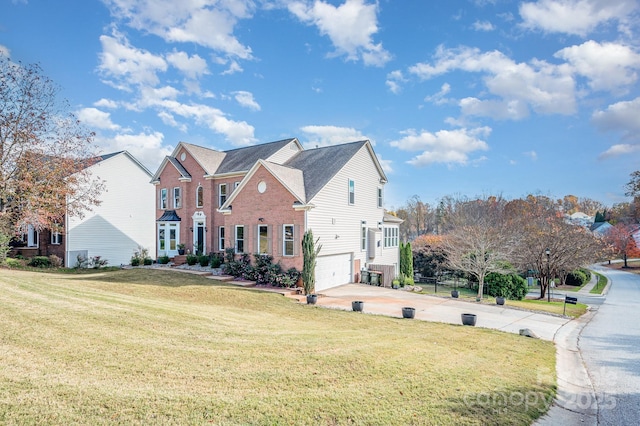 view of front of property featuring a garage, driveway, a front lawn, and brick siding