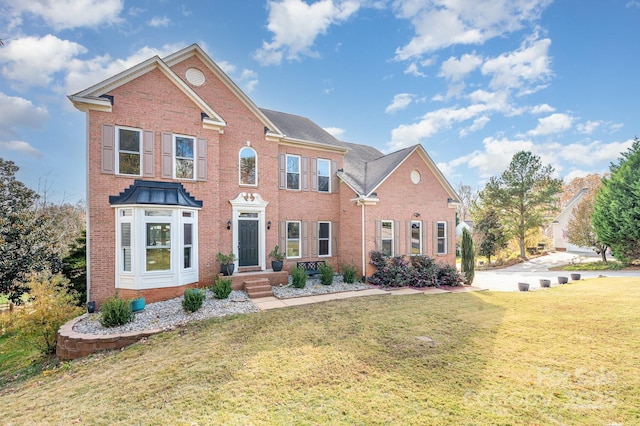 view of front of property featuring a front lawn and brick siding