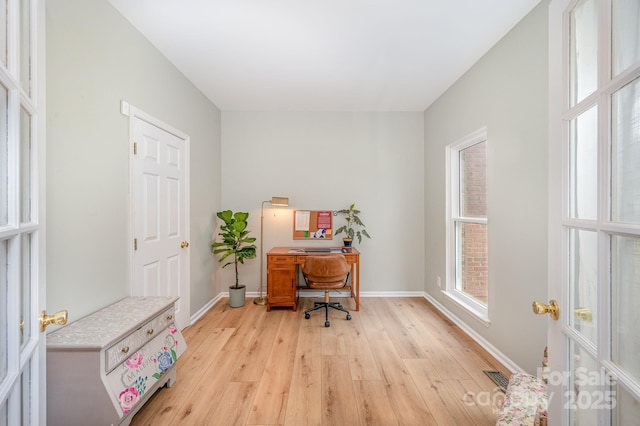 office area featuring light wood-style flooring, visible vents, and baseboards