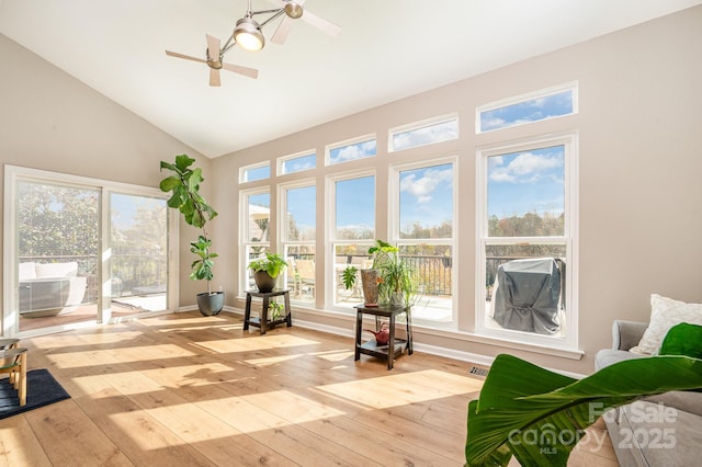 sunroom featuring lofted ceiling and a ceiling fan