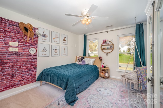 carpeted bedroom featuring brick wall, ceiling fan, visible vents, and baseboards