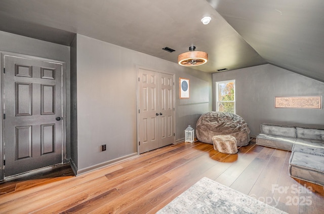 bedroom featuring lofted ceiling, wood-type flooring, visible vents, and baseboards