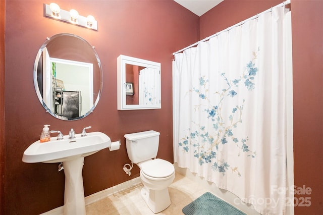 bathroom featuring toilet, shower / bath combo, baseboards, and tile patterned floors