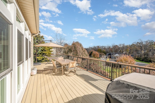 wooden terrace with outdoor dining space and grilling area