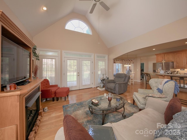 living area featuring french doors, recessed lighting, ceiling fan, high vaulted ceiling, and light wood-type flooring