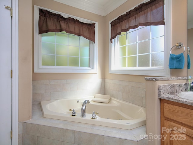 bathroom with ornamental molding, a jetted tub, and vanity