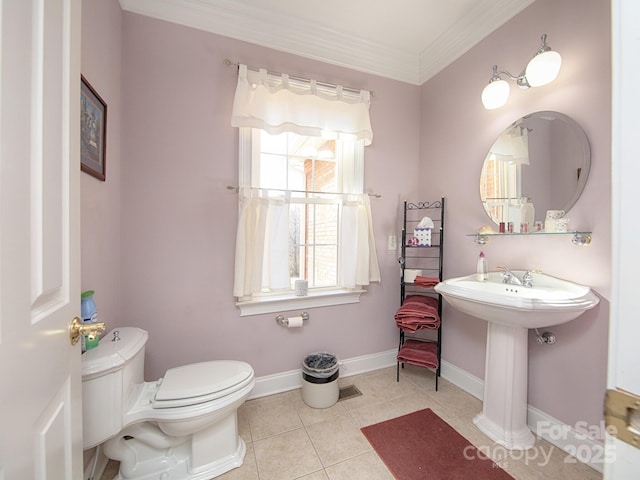 half bath with toilet, ornamental molding, a sink, tile patterned flooring, and baseboards