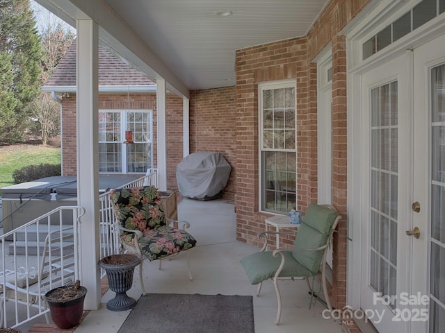 view of patio with french doors, a hot tub, and grilling area