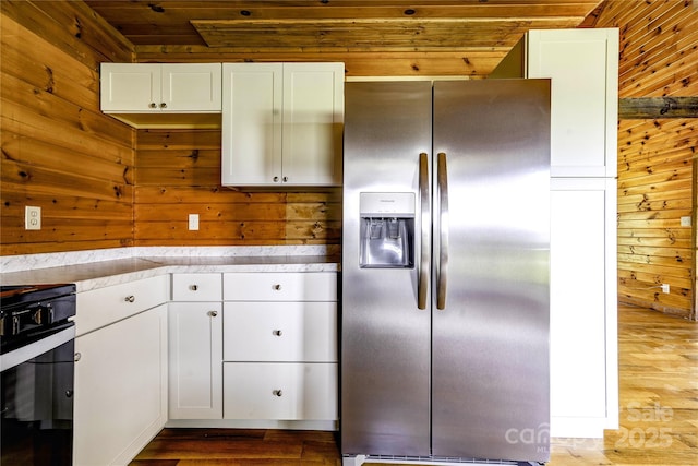 3640 Oak Haven Ln, Shelby, NC 28150 - kitchen featuring stainless steel fridge, wood finished floors, range, wood walls, and white cabinets