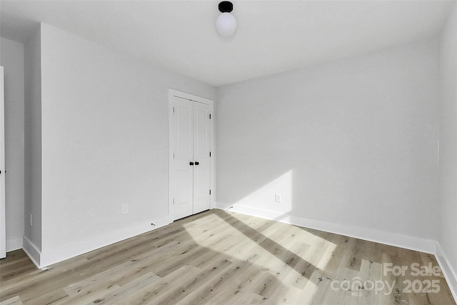 empty room with baseboards and wood finished floors