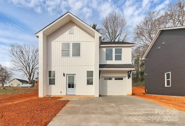 view of front facade with concrete driveway, an attached garage, board and batten siding, and roof with shingles