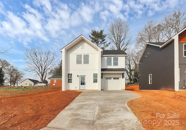 modern inspired farmhouse featuring an attached garage, concrete driveway, and roof with shingles