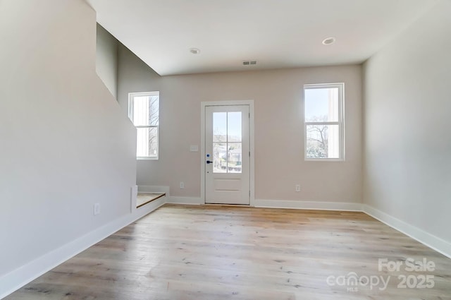 foyer with baseboards, visible vents, a healthy amount of sunlight, and light wood-type flooring