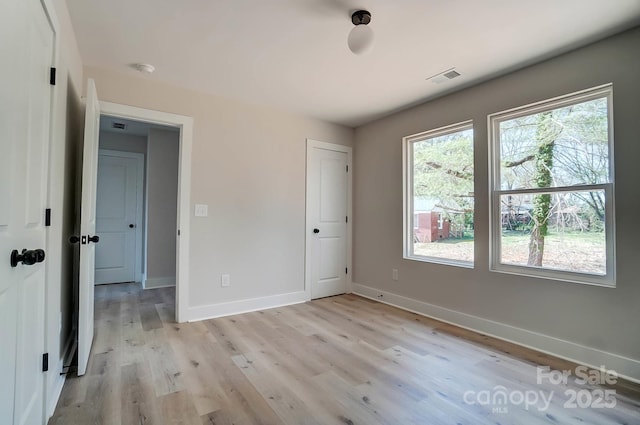 unfurnished bedroom with baseboards, visible vents, and light wood-type flooring