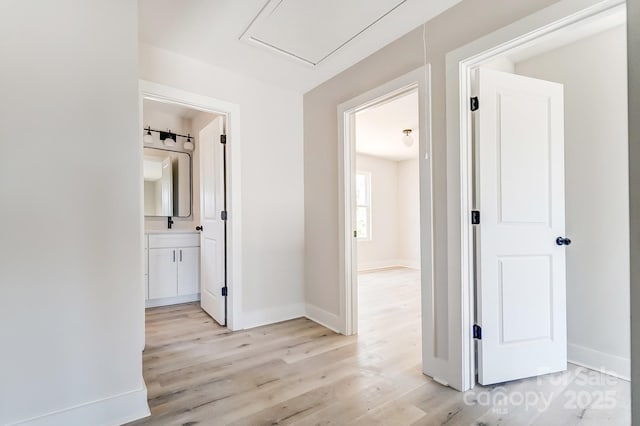 corridor featuring baseboards and light wood-type flooring