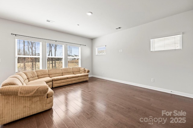 living room with baseboards, visible vents, and dark wood finished floors