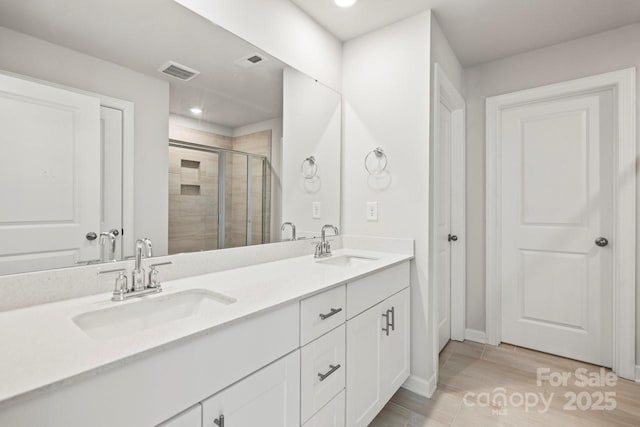 full bath with double vanity, a stall shower, visible vents, and a sink