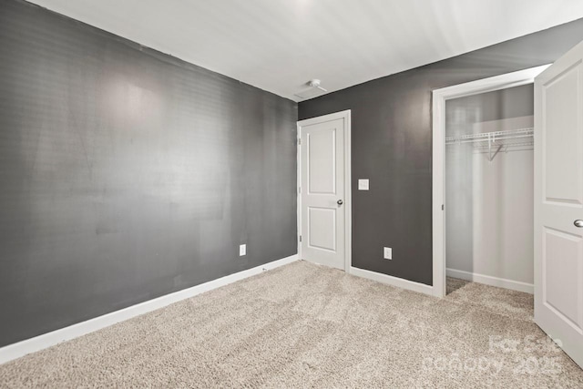 unfurnished bedroom featuring carpet floors, a closet, and baseboards