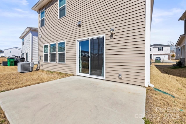 back of house featuring a yard, central AC unit, and a patio area