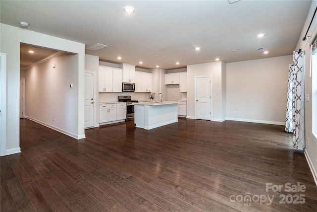 2131 Belterra Dr, Charlotte, NC 28216 - kitchen featuring appliances with stainless steel finishes, an island with sink, baseboards, dark wood-style floors, and recessed lighting
