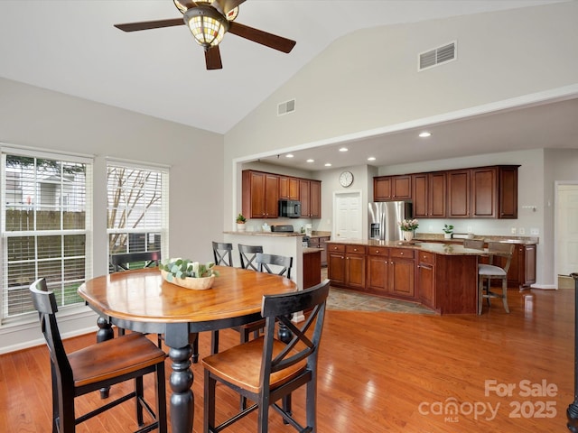 dining area with visible vents, light wood-style flooring, and ceiling fan