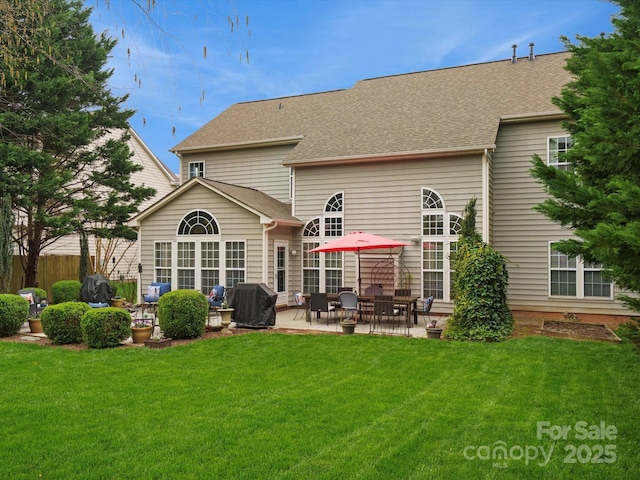 back of property with a patio, a lawn, and roof with shingles