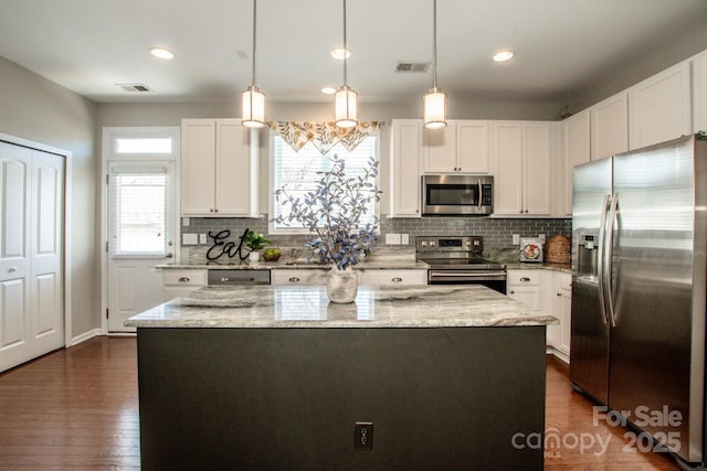 kitchen featuring light stone countertops, a kitchen island, visible vents, and stainless steel appliances