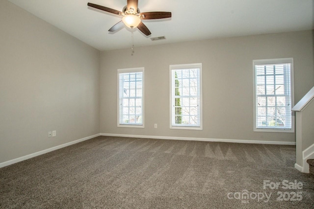 carpeted empty room featuring plenty of natural light, visible vents, and baseboards