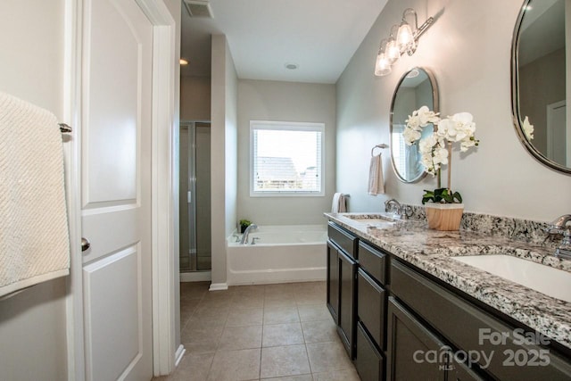 bathroom featuring a garden tub, tile patterned flooring, visible vents, and a sink