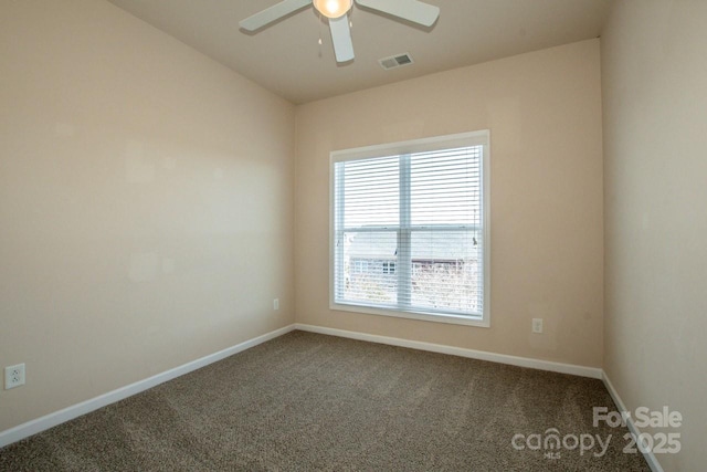 spare room featuring carpet floors, baseboards, visible vents, and a ceiling fan