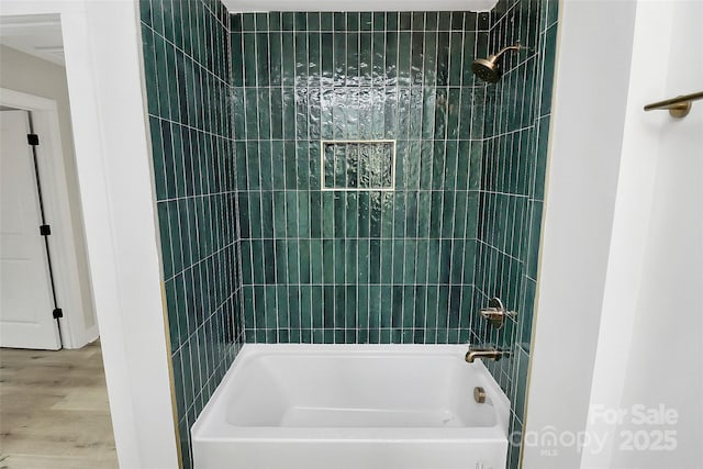 bathroom featuring  shower combination and wood finished floors