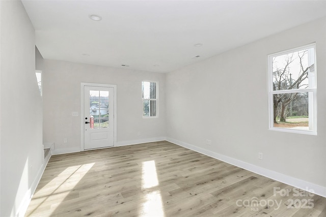 spare room featuring recessed lighting, light wood-type flooring, and baseboards