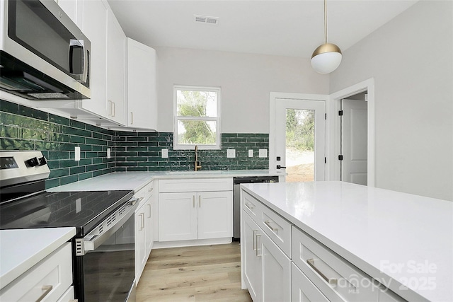 kitchen featuring light countertops, backsplash, visible vents, and appliances with stainless steel finishes